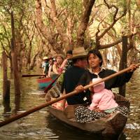 Women of the stilt village in Kompong Phluk on Cambodia’s Tonle Sap lake guide tourists through the flooded forest. | MIDORI PAXTON