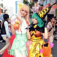 Two young women pose during the Ikebukuro Halloween Cosplay Festival in Tokyo on Saturday. The costume-based event ends at 6 p.m. Sunday. | YOSHIAKI MIURA