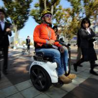 Segway Japan Vice President Dai Akimoto holds a demonstration using the Genny wheelchair, manufactured in Italy, in Tsukuba, Ibaraki Prefecture, on Friday. | AFP