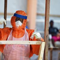 A health worker operates Tuesday in the red zone of the Hastings treatment center outside Sierra Leone\'s capital, Freetown, the only facility run exclusively by locals. Some 1,130 people in the impoverished west African country have died from the Ebola virus out of 4,862 cases in the current outbreak. | AFP-JIJI