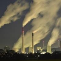 Smoke streams from the chimneys of the E.ON coal-fired power station in Gelsenkirchen, Germany, on Monday night. | AP