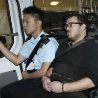 Rurik George Caton Jutting, a 29-year-old British securities trader for Bank of America Merrill Lynch who has been charged with murdering two prostitutes in Hong Kong, arrives in a police van at a local court. Police found the bodies of two women in Jutting\'s apartment on Saturday night. One of them had been stuffed in a suitcase on his balcony. | REUTERS