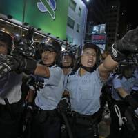 Police officers shout at protesters in Hong Kong\'s Mong Kok district Tuesday evening. | AP