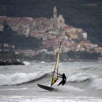 A windsurfer sails along the north coast of Italy In Andora, western Genova, on Tuesday. Italian authorities say the recent heavy rains leave the mountainous nation subject to extreme flooding and landslides. | AFP-JIJI