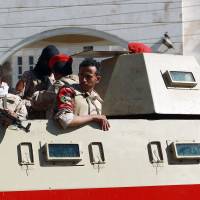 Yemeni security forces hold a position outside a court during a hearing for al-Qaida suspects accused of undermining state security at their trial in Sanaa on Tuesday. | AFP-JIJI