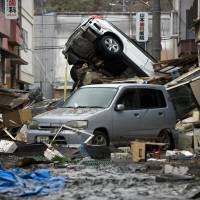 Cars sit abandoned in Ishinomaki, Miyagi Prefecture, on March 15, 2011, four days after the Tohoku region was hit by a massive earthquake and tsunami. | BLOOMBERG