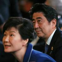 Prime Minister Shinzo Abe and South Korean President Park Geun-hye attend an event at the Group of 20 summit in Brisbane, Australia, on Nov. 15. Both nations face controversies over how textbooks depict contentious historical events. | REUTERS