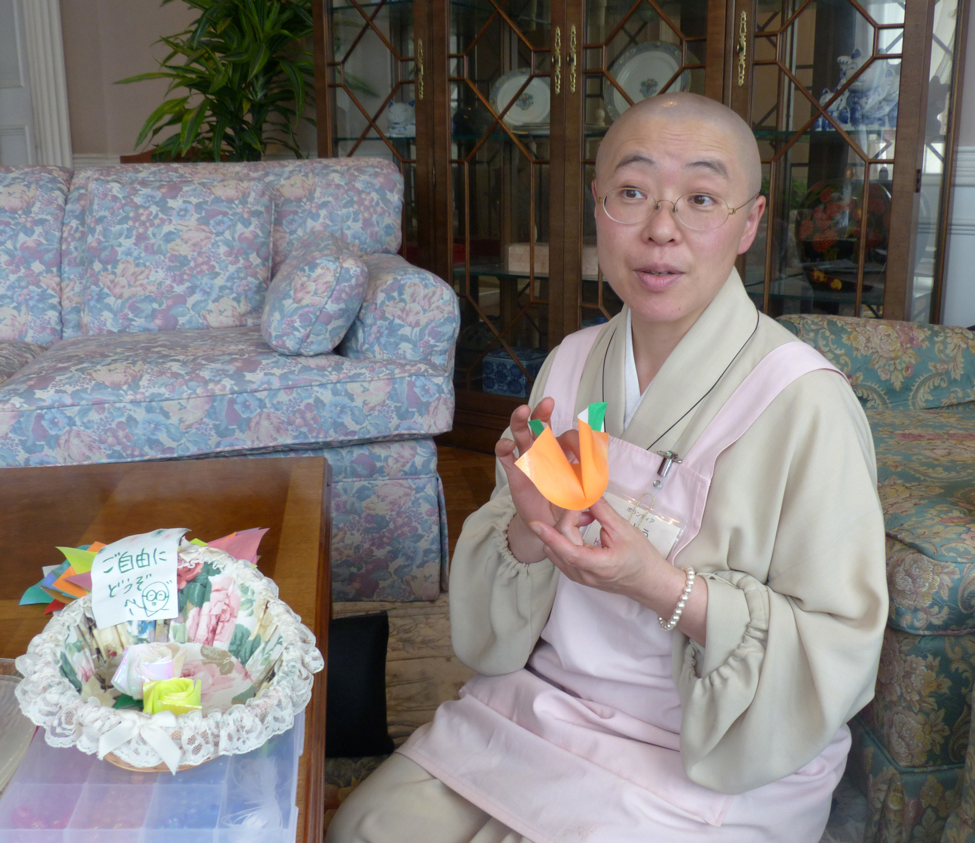Jito Sasaki, a nun in Nara Prefecture, folds a piece of origami paper at a hospice in Tokyo, where she volunteers several days a month. | KYODO
