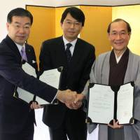 Japan External Trade Organization President Satoshi Miyamoto (left) poses with Kyoto Gov. Keiji Yamada (center) and Kyoto Mayor Daisaku Kadokawa (right) on Friday after informing them about the establishment of a new information center in Kyoto. | KYODO