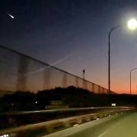 An image posted on YouTube by a motorist in Nogata, Fukuoka Prefecture, shows what looks like a meteor flashing across the sky Monday night. | KYODO