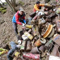 Ken Noguchi collects empty cans and other rubbish with other volunteers at the base of Mount Fuji in April. Heritage listing a wake-up call for taking charge of Mount Fuji cleanup