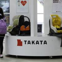 A visitor walks past Takata Corp. displays at a showroom in Tokyo on Nov. 5. | REUTERS