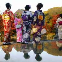 Tourists wearing kimono visit a park in Kyoto on Wednesday. | REUTERS
