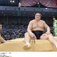 Self-reflection: Harumafuji sits on the edge of the ring after losing to Takayasu (left) at the Kyushu Grand Sumo Tournament in Fukuoka on Monday. | KYODO