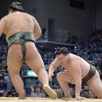 Rare loss: Yokozuna Hakuho stumbles against Takayasu on Friday at the Kyushu Grand Sumo Tournament. | KYODO
