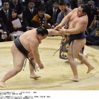 Not so fast: Kisenosato (left) forces Kakuryu out of the ring at the Kyushu Grand Sumo Tournament in Fukuoka on Wednesday. | KYODO