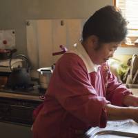  Toshiko Nakamura washes dishes in her kitchen in Keishi, Ooka village, Nagano Prefecture. | SKYE HOHMANN