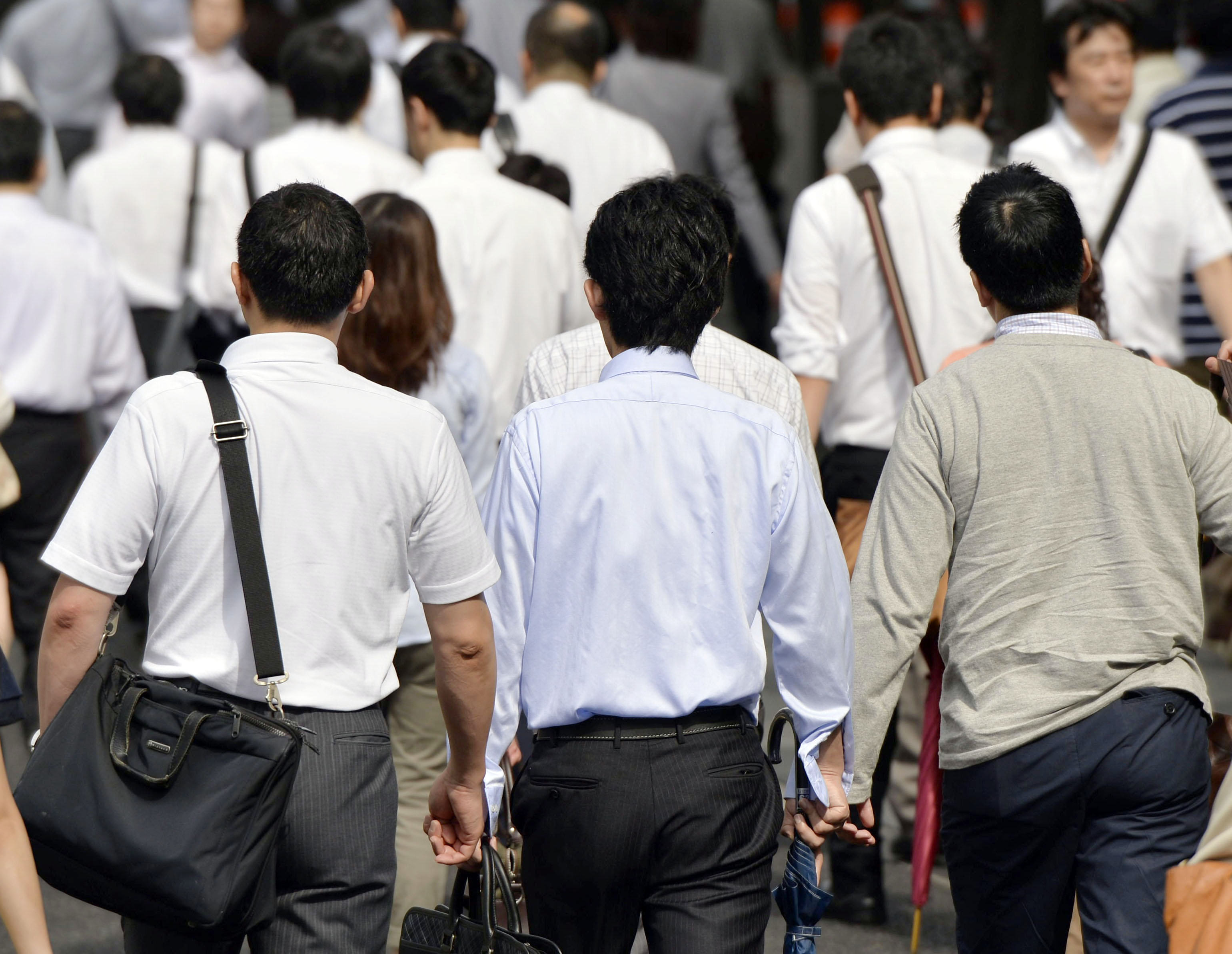Morning march: Japanese workers make their way through Tokyo during the morning commute. | KYODO