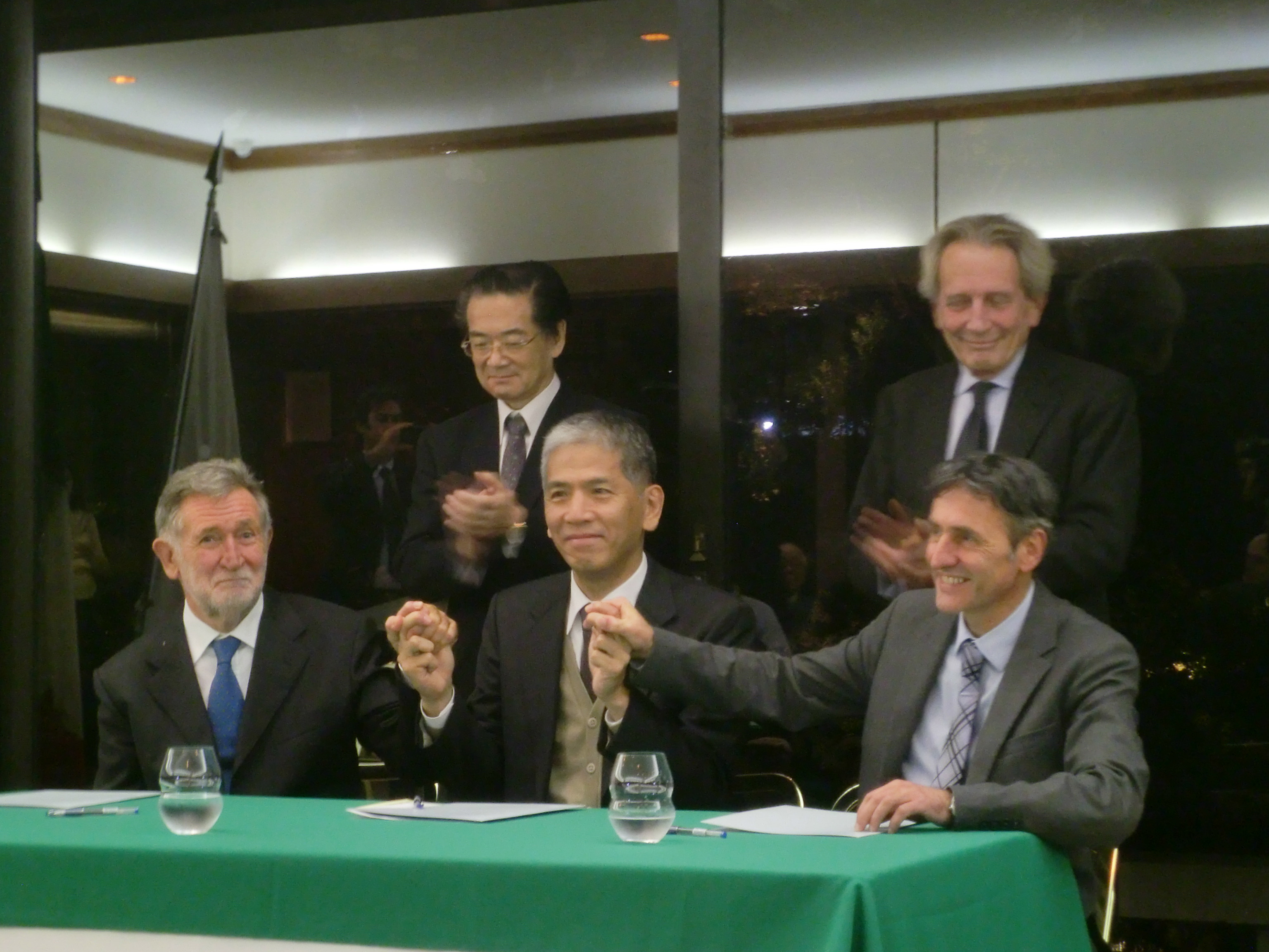(Front row from left) professor Paolo Strolin, deputy president of the INFN; professor Takehiro Koyaguchi, director of the ERA; and Paolo Papale, director of the INGV's volcano section, sign a letter of intent in the presence of the Italian Ambasador Domenico Giorgi (second row, right) and Makoto Katsura, ambassador for science and technology cooperation of the Ministry of Foreign Affairs on Nov. 12 at the Italian Embassy in Tokyo. | CHIHO IUCHI