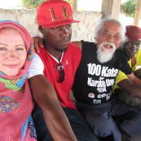 Bass vs. base: Catherine Jane Fisher and Ugandan band members Baswali Kiramu and Musa Jian (right) join Okinawan anti-war sculptor Minoru Kinjo for a beach barbecue in Yomitan, central Okinawa, on Sunday. | JANE CLOSE