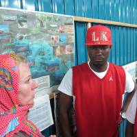 Under threat: Activist Catherine Jane Fisher shows musicians Baswali Kiramu (left) and Musa Jian a map of the planned Henoko relocation. | JANE CLOSE