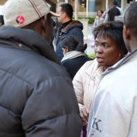 Elizabeth Obueza speaks with fellow members of the Provisional Release Association of Japan (PRAJ) before a protest on Nov. 19. Obueza was recently arrested for traveling within Japan to advocate for detainees, an act authorities said was a violation of her own provisional release. Detainees released provisionally are expected to find a way to obtain housing and work without any assistance. That gap has been filled by volunteers and activists. | DREUX RICHARD