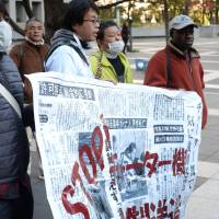 Members of PRAJ prepare to march from Shinagawa Station to the Immigration Bureau in protest on Nov. 19. The protest was attended by roughly 220 people representing 17 nationalities. Obueza organizes the African members of PRAJ and serves as the association\'s primary point of contact in the English language. | DREUX RICHARD