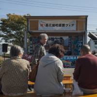 Catching up: Locals listen to live music and taiko drumming at the monthly Fukko Ichi, or Revival Market, in Minamisanriku. | SKYE HOHMANN