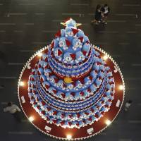 People take photos of a Christmas tree decorated with the manga character Doraemon at a shopping mall in Singapore\'s central business district on Monday. | REUTERS