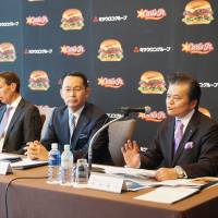 Masato Watanabe (right), president of Carl\'s Jr. Japan Inc., speaks to reporters in Tokyo as Mitsuuroko Group Holdings Co. CEO Kohei Tajima and Michael Murphy, president of CKE Restaurants Holdings Inc., look on. | KAZUAKI NAGATA