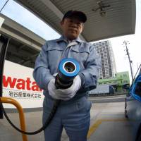 An Iwatani Corp. employee prepares to fill a Toyota Mirai fuel cell vehicle at a hydrogen fueling station in Tokyo on Nov. 17. | BLOOMBERG