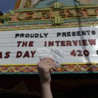 Tickets to \"The Interview\" are held up by Crest Theater manager Donald Melancon in Los Angeles on Wednesday. | REUTERS