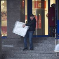 A man carries a dishwasher from a shop in St. Petersburg, Russia. The collapse of the ruble triggered a spending spree by Russians desperate to buy cars and home appliances before prices increase. | AP