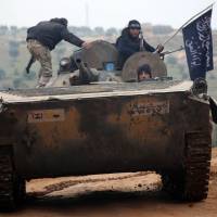 Fighters from the Nusra Front, al-Qaida\'s Syrian branch, drive a seized tank during a battle Friday outside the northern city of Aleppo. | AFP-JIJI