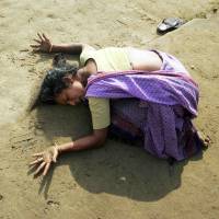 An Indian woman mourns beside a relative killed in the Dec. 26, 2004, tsunami in Cuddalore, 180 km south of Madras, two days after the catastrophe. | REUTERS