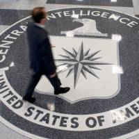A man crosses the Central Intelligence Agency logo in the lobby of CIA Headquarters in Langley, Virginia, in August 2008. In the wake of a critical Senate report, CIA Director John Brennan insisted Tuesday that agents’ use of brutal interrogation techniques against al-Qaida suspects helped prevent attacks. | AFP-JIJI