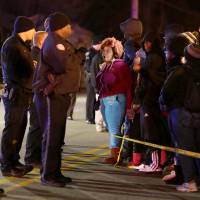 Protesters yell at police protecting the perimeter of a scene where a teenager was fatally shot by a police officer earlier at a Mobil gas station on North Hanley Road in Berkeley, Missouri, on Wednesday. The 18-year old black man was shot and killed by police late Tuesday in the St. Louis suburb near where unarmed teen Michael Brown was killed by a white officer in August. | REUTERS