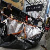 Pro-democracy demonstrators pack up a tent before police clear the site, the third of three camps to close, at the Causeway Bay shopping district in Hong Kong on Monday. | REUTERS