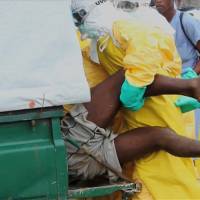 Health workers push an Ebola patient who escaped from quarantine at Monrovia\'s ELWA Hospital into an ambulance in the center of Paynesville, Liberia, in this file still image taken from a Sept. 1 video. The World Health Organization said Liberia erroneously added 1,000 people to the nation\'s Ebola death toll over the weekend. | REUTERS