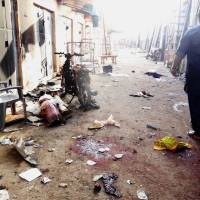 A man walks past blood stains and rubble after twin suicide blasts at the Kantin Kwari textile market in northern Nigeria\'s commercial city of Kano on Wednesday. Two female suicide bombers killed at least four people at the busy market in Kano, less than two weeks after a horrific attack at the city\'s central mosque. Kano state police commissioner Adenrele Shinaba said the blasts at the market in Kano city were \"a twin suicide bombing carried out by two young girls in hijab.\" | AFP-JIJI