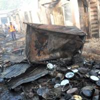 People inspect damaged shops Tuesday following a Monday bomb explosion at a market in Bauchi in northeast Nigeria, where Boko Haram insurgents have been committing bloodshed for years. | AP