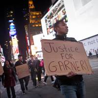 People stage a protest Wednesday in Midtown Manhattan over the Staten Island death of Eric Garner during an arrest in July. A New York City grand jury decision not to charge white police officer Daniel Pantaleo. who killed the unarmed black man Garner with a chokehold, sparked outrage and protests that continued into Thursday morning, leading to scores of arrests. The U.S. Justice Department said it would investigate the incident. | REUTERS