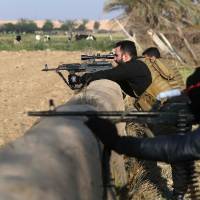 Pro-Iraqi government fighters take part in an operation to secure an area seized from Islamic State militants in the town of Yathreb, 75 km north of Baghdad, on Monday. | AFP-JIJI