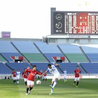 Locked out: Urawa Reds play Shimizu S-Pulse in an empty Saitama Stadium in March. | KYODO