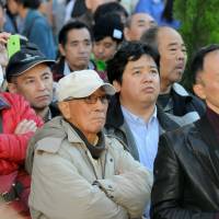 Potential voters listen as campaigning for the Dec. 14 Lower House election gets underway in Tokyo\'s Shinjuku district Tuesday. | SATOKO KAWASAKI