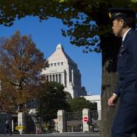 A guard walks past the Diet building on Nov. 21, the day Prime Minister Shinzo Abe dissolved the Lower House and scheduled a snap election for Dec. 14. | REUTERS