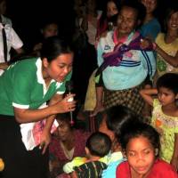 A member of the Japan International Volunteer Center asks villagers in Laos how they feel after watching local students perform a play about land rights. | JAPAN INTERNATIONAL VOLUNTEER CENTER