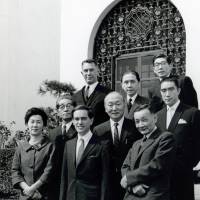 Donald Keene (front center) poses for a photo with Haru Reischauer (front left), wife of then U.S. Ambassador to Japan Edwin Reischauer (third row, left), renowned author Yukio Mishima (second row, right) and others in front of the U.S. Ambassador\'s Residence in Tokyo upon receiving the Kikuchi Kan Prize in 1962. | COURTESY OF DONALD KEENE