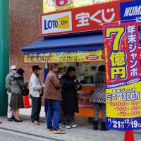 People queue to buy lottery tickets from Ube\'s luckiest outlet, in Kotoshiba, in November. Tickets bought in Ube have resulted in a slew of jackpots over the past six years, and the city is capitalizing on its renown by offering tickets in exchange for municipal donations. | KYODO
