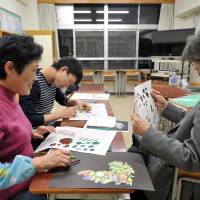 Dong Xiao Mong (left), a student from China, takes an art lesson at Bunka Junior High School in Tokyo on Dec. 10. | YOSHIAKI MIURA